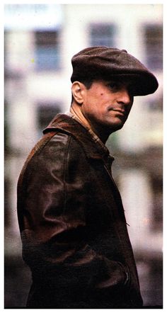 a man wearing a brown leather jacket and hat