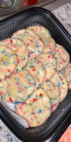 there are many cookies that have sprinkles on them in the pan and ready to be eaten