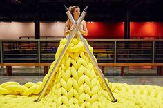 a woman standing on top of a giant pile of bananas with two swords in her hand