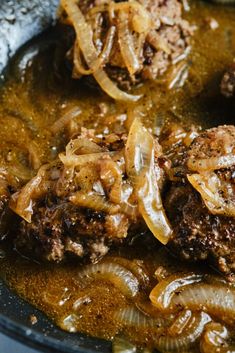 some meat and onions are cooking in a pan