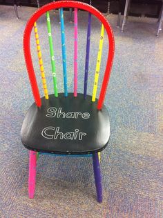 there is a chair that has been painted with different colors and writing on the back