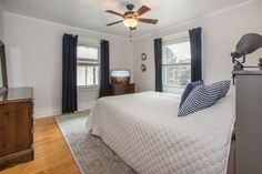 a bed room with a neatly made bed and a flat screen tv