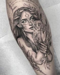 a woman with an owl tattoo on her arm is holding it's face up