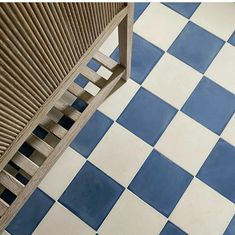 a wooden bench sitting on top of a blue and white checkerboard tile floor