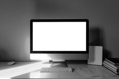 a desktop computer sitting on top of a desk next to a stack of books and a mouse