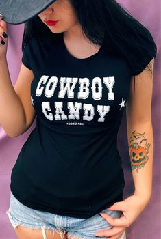 Cowboy Candy Country Pinup Tee BRAND: RODEO FOX by Demi Loon Details: 95% cotton 5% Spandex Our original Cowboy Candy Graphics Perfect alternative cowgirl country t-shirt Printed on a fitted women's Stretch slim fit tee Give it an extra cowgirl kick by knotting up the front Sizing: Fit Guide: Model 34" bust wearing size Small Small: 33-34" bust 26-27" waist Medium: 35-36" bust 28-31" waist Large: 37-39" bust 32-33" waist X-Large: 40-41" bust 34-35" waist 2XL: 42-43" bust 36-38" waist 3x: 44-46" bust 39-43" waist sku: CC7-BLK CC17-RED Fitted Graphic Print T-shirt For Rodeo, Pre-shrunk Tops For Rodeo In Fall, Graphic Print T-shirt For Rodeo, Fitted Crew Neck T-shirt For Rodeo, Fitted Crew Neck Top For Rodeo, Fitted Graphic Print Tops For Rodeo, Fitted T-shirt For Rodeo In Fall, Trendy Fitted Tops For Rodeo, Rodeo Short Sleeve Tops With Letter Print