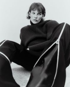 a black and white photo of a woman sitting on the floor