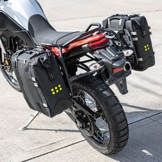 a motorcycle parked on the street with its luggage strapped to it's back end