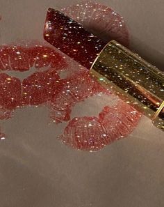 a lipstick with glitters on it sitting next to a mirror