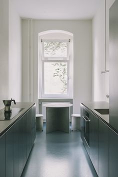 an empty kitchen with stainless steel appliances and counter tops, along with a large window