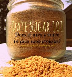 a jar filled with dirt sitting on top of a table next to a pile of sand