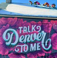 a mural on the side of a building that says talk denver to me with flowers painted all over it