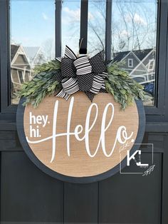 a door hanger that says hey hi hello with a bow and evergreen wreath on it