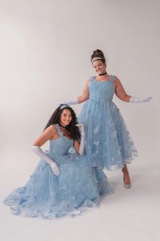 two women in blue dresses posing for the camera