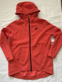 Up for auction is this beautiful NIKE SPORTSWEAR  WOMEN'S HOODIE JACKET in beautiful orange-red color Cotton/Poly Blend double knit, generously oversized cut bodice, longer rounded hem at back, attached hood, two way zipper at front, large pockets, black Nike logo at left chest, long, cuffed sleeves (please see pictures above for design, look and style detail), NWT, original retail $120...  NIKE  SPTCAS    WOMEN'S HOODIE JACKET    STYLE 811710    COLOR 850 (ORANGE/RED)    SIZE M     NEW   TAGS IN POCKET     ORIGINAL RETAIL $120 What a fabulous NIKE HOODIE JACKET. Great style, Great Color, oversized bodice and just perfect for all your outdoor and all your casual days and wherever you're on the go.... anytime, any season.... Measurement are:  Back width arm pit to arm pit 23", back center l Black Nike Logo, Hoodie Jacket Women, Nike Sportswear Women, Women's Hoodie, Red Nike, Double Knit, Zip Up Hoodies, Nike Hoodie, Black Nike