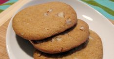 three cookies on a white plate next to other cookies