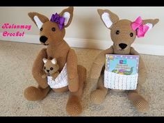 two stuffed kangaroos sitting next to each other on the floor with a book in their hands