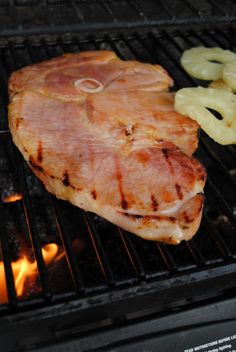 a piece of meat sitting on top of a grill next to some sliced up bananas