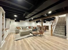 a living room filled with lots of furniture and a stair case in front of the couch