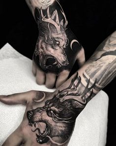 two men with tattoos on their arms and hands are holding each other's hands