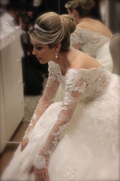 a woman in a wedding dress looking at her phone