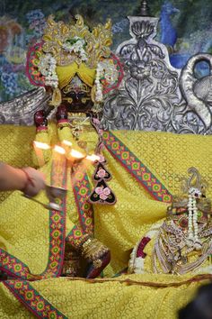 a person lighting candles in front of a statue