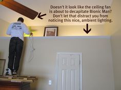 a man standing on top of a wooden table next to a wall with an arrow pointing towards the ceiling