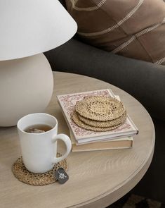 a stack of books sitting on top of a table next to a cup of coffee