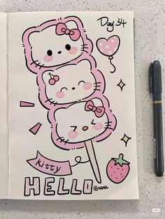 a hello kitty drawing on top of a notebook next to a pen