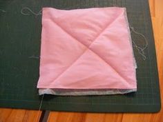 a piece of pink fabric sitting on top of a cutting board