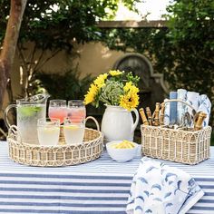 two wicker trays with drinks on top of a blue and white table cloth