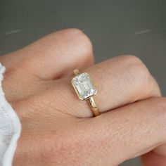 a woman's hand with a ring on it and a diamond in the middle