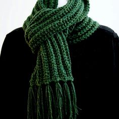 a green knitted scarf on top of a mannequin