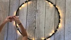 a person holding their hands up in front of a circle with lights on the side