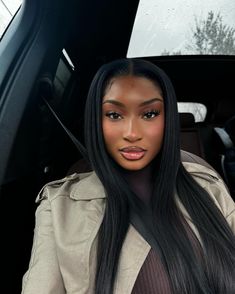 a woman with long black hair sitting in a car