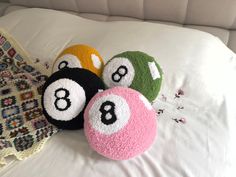 three balls with numbers on them are laying on a white bed sheet and next to a blanket