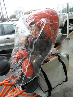 a little boy sitting on top of a motorcycle in a plastic bag over his head