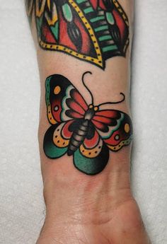 a colorful butterfly tattoo on the wrist and foot is featured in this image, it appears to be done by an artist