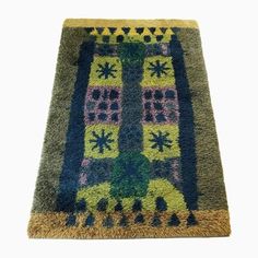 an area rug with a tree on the top and blue, green, yellow and pink colors