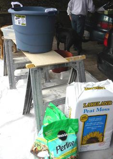 there is a bag of fertite next to a table with a bucket on it