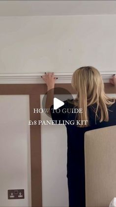 a woman is painting the wall with white paint and she has her hands on the paneling