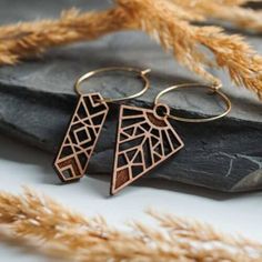 two wooden earrings sitting on top of a rock