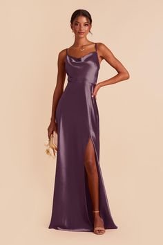 a woman in a long purple dress posing for the camera with her hand on her hip