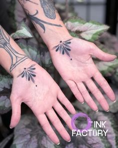 two hands that have tattoos on them