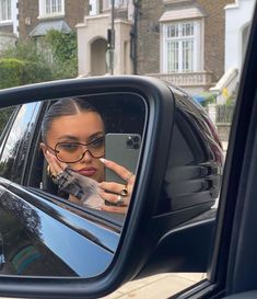 a woman taking a selfie in the side mirror of a car