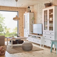 a living room filled with furniture and a flat screen tv sitting on top of a wooden floor