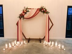 a wedding arch with candles and flowers on it