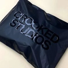 a black bag with the word crooked studios printed on it's front and sides