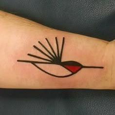 a tattoo on the arm of a person with a red and black bird in it