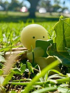 an egg is sitting in the grass with its head sticking out from it's shell